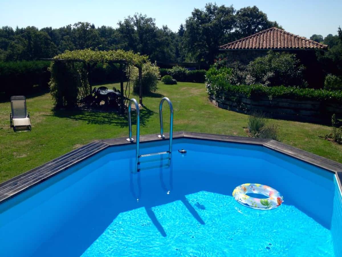 Piscine privée entourée du jardin du gîte du Bois de Pommeau